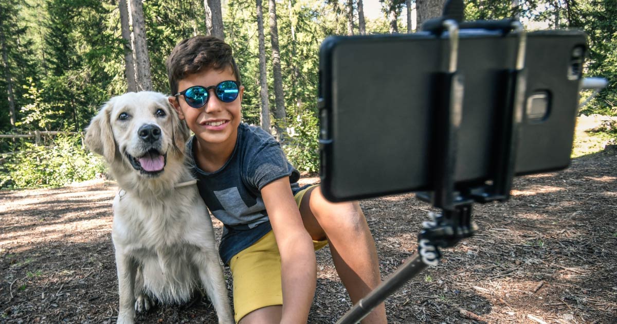 Boy taking a selfie with his Labrador dog