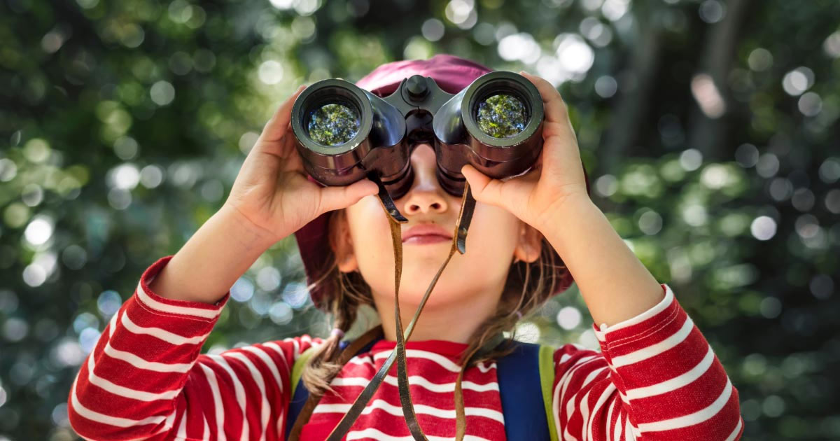Girl looking through a pair of binoculars